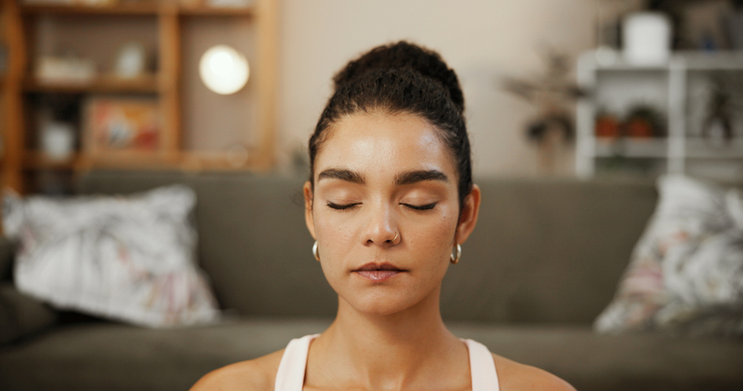 Woman, home and meditation exercise for healing spirit, mindfulness and activity for stress relief. Yoga, fitness and eyes closed for breathing practice in living room, chakra and self care for calm